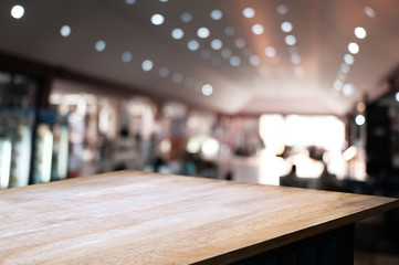 empty wooden table over blur restaurant / coffee shop cafe background