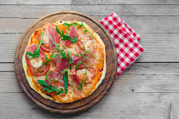 Italian pizza with prosciutto and arugula