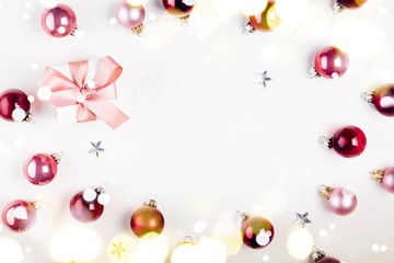 Christmas flat lay frame with pink abd violet glass balls and gift box with lights