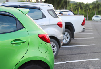 Closeup of rear side of green car park in parking area with natural background in the evening.