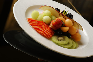 Fruit cocktail with melon, strawberry, kiwi, papaya, blackberry, pineapple and apple. Accompanied by a basket of sweet bread with green and orange juice