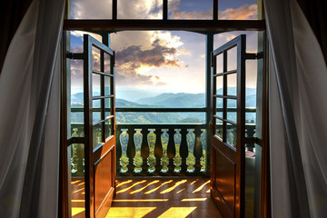 Beautiful Golden Hour and Himalayan ranges seen from hotel room through wooden glass door