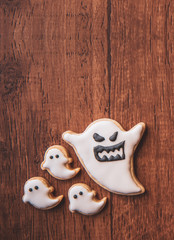 Fresh delicious homemade decorated halloween cookies sweets on dark wooden background, concept of halloween party, copy space(text space), top view, blank for text.