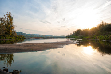 Scenic sunset with reflections in the river; Isles with still water not touched by human; Vistula river seen near Kazimierz Dolny, Poland, Polska