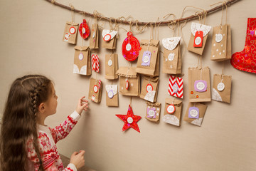 child looks at the advent calendar. option DIY to wait for Christmas for kids