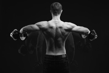 Fototapeta na wymiar Black and white conept image Dumbbell Lateral Raise Bodybuilder turning back raising hands pumping up shoulders muscle exercise Power Partials routine with dumbbells on gym Dramatic studio shot