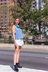 Full length Portrait of student tourist girl standing in the streets. Bright day light. Concept of confident, active, summer leisure.