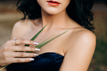 Seductive woman holds delicate green leaf in her arms