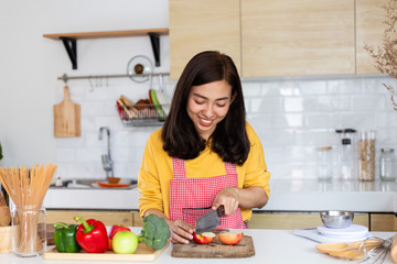 Healthy food Asian woman is cooking salad in kitchen, female preparing the vegetables and fruit at her house