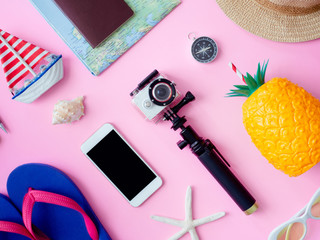 top view travel concept with retro camera films, map, passport, smartphone, action camera and compass on pink background, Tourist essentials, vintage tone effect