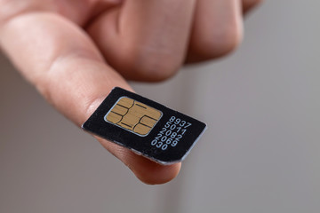 Close - up of the SIM card lying on the boy's finger.