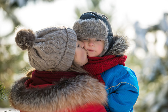 Mother kissing son in winter