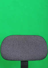 Office chair back on green background with space for text