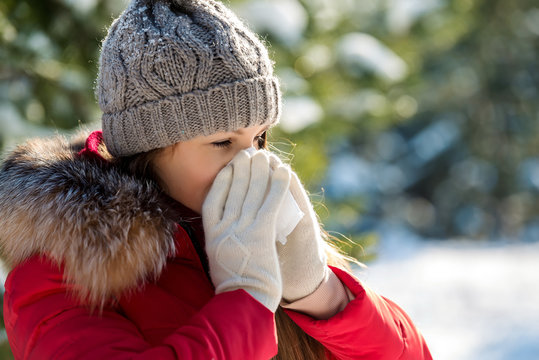 Young woman is sick in winter and sneeze