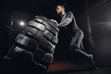 Man flipping tire wheel. Concept lifting, workout training.