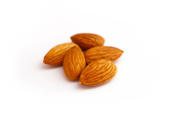 A pile of almond nuts macro view, isolated on white background.