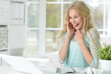 Portrait of surprised girl looking at laptop