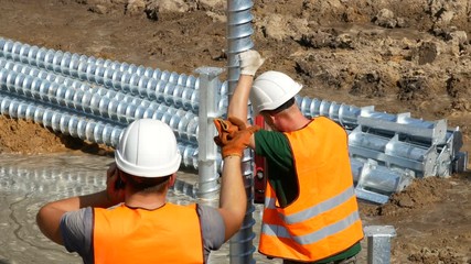 worker controls the angle at which the pile goes into the ground. construction of the foundation
