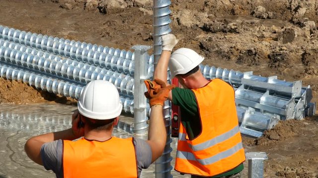 worker controls the angle at which the pile goes into the ground. construction of the foundation
