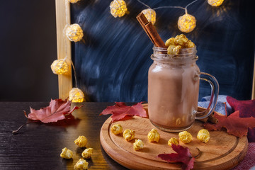 Obraz na płótnie Canvas cocoa with popcorn and cinnamon on a slate background with lights
