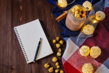 cocoa with popcorn and cinnamon on the table with an open notebook and fountain pen