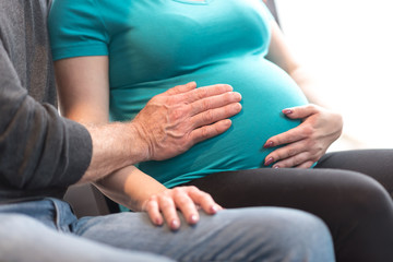Couple with hands on pregnant belly