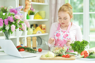 Obraz na płótnie Canvas Portrait of teen girl preparing fresh salad