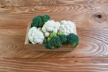 Assortment of cabbages in the box on old wood background. Seasonal harvest crop local produce concept. Authentic lifestyle image. Flat lay. Top view