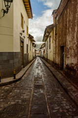Fototapeta na wymiar View of a classic cobblestone street with antique buildings in Cusco, Peru