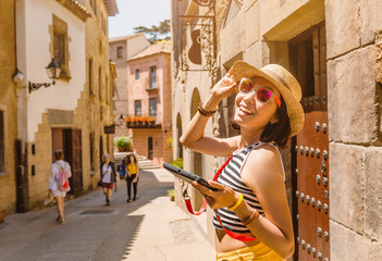 Fototapeta na wymiar Young woman with digital gadget in the old historical streets of Spain