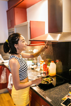 Woman cooking on modern induction cooker stove in the kitchen