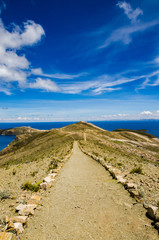 Vertical landscape on Isla del Sol with a blue Titikaka Lake and a blue sky