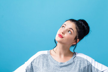 Young woman looking upwards on a solid background