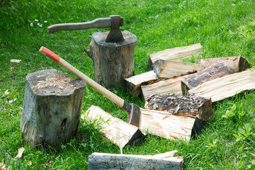 ax and cleaver on chopped firewood on a summer day