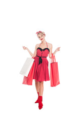 young woman in retro pin up clothing with shopping bags isolated on white