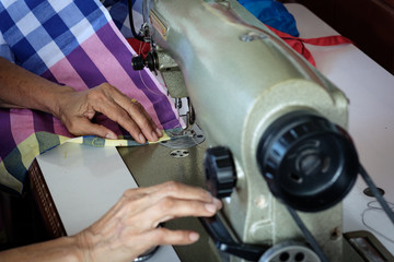 Woman's hands sewing fabric  repairs on old sewing