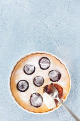 Homemade Plum Clafoutis on Blue Concrete