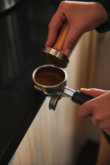 Fototapeta na wymiar close-up partial view of barista preparing coffee in coffee maker