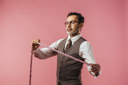 Portrait Of Tailor Holding Tape Measure