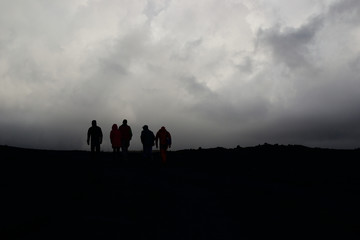 Five people silhouettes on gloomy sky