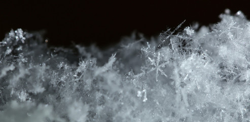 Snowflakes on a black background close up. Winter background, macro photo of snowflakes. 