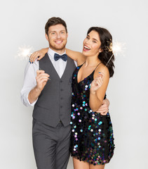 celebration, fun and holidays concept - happy couple with sparklers at party