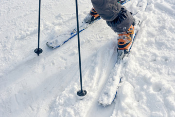 Fototapeta na wymiar Snowy winter background with boots standing on ski on track