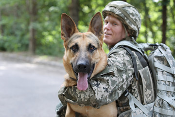 Man in military uniform with German shepherd dog, outdoors