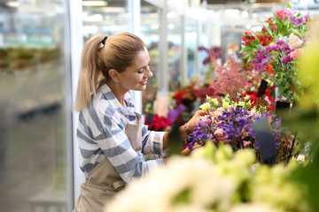 Belle femme fleuriste travaillant dans un magasin de fleurs