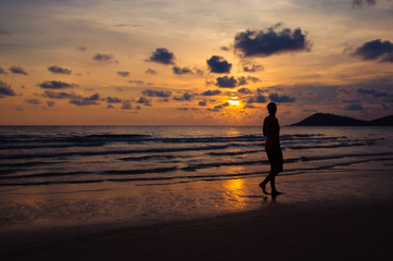 Fototapeta na wymiar silhouette sunset with girl walking on beach