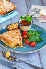 Giant chicken samosas with mango chutney and fresh salad, sprinkled with sesame seeds