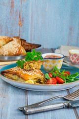 Giant chicken samosas with mango chutney and fresh salad, sprinkled with sesame seed