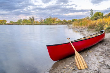 red canoe on a lake shore