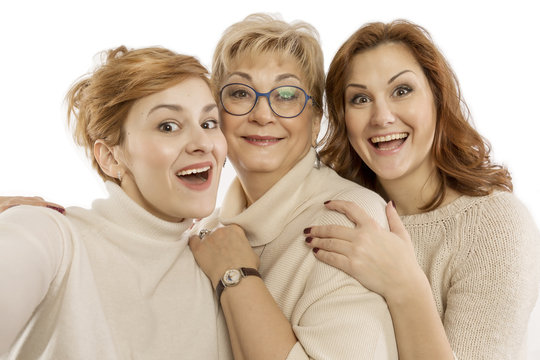 Mature mom with adult daughters laugh and take pictures, happy family